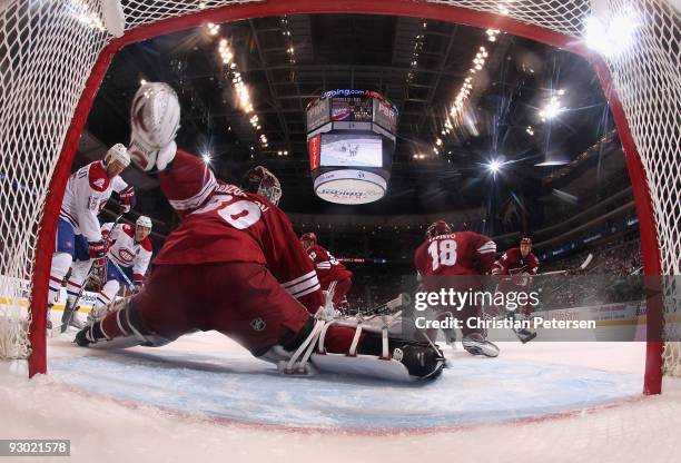 Goaltender Ilya Bryzgalov of the Phoenix Coyotes makes a pad save on the a shot from the Montreal Canadiens as Glen Metropolit skates in during the...