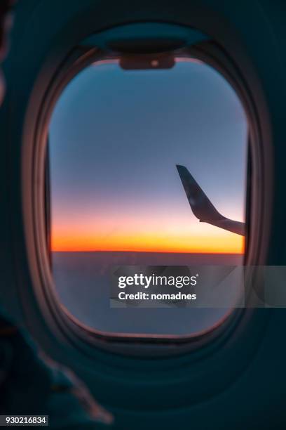 sunset over horizon,looking through from airplane window. - plane windows stock pictures, royalty-free photos & images