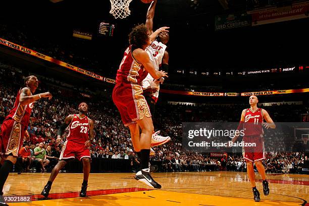 Dwyane Wade of the Miami Heat dunks against Anderson Varejao of the Cleveland Cavaliers on November 12, 2009 at American Airlines Arena in Miami,...