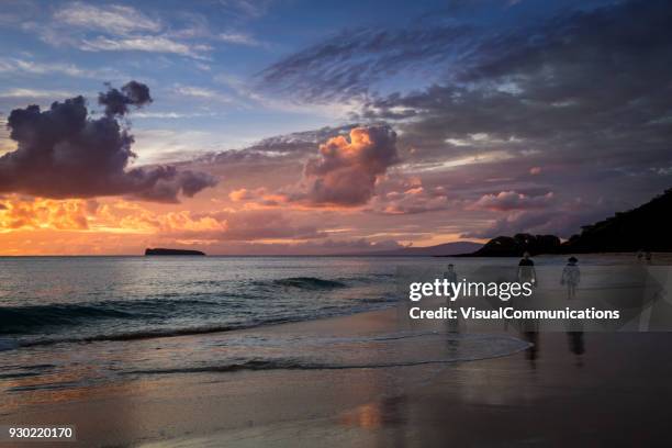 tourists walking on beach during sunset. - makena beach stock pictures, royalty-free photos & images