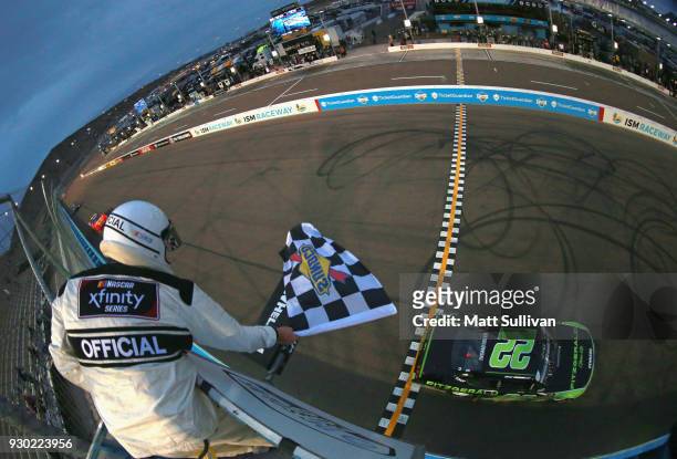 Brad Keselowski, driver of the Fitzgerald Glider Kits Ford, takes the checkered flag to win the NASCAR Xfinity Series DC Solar 200 at ISM Raceway on...