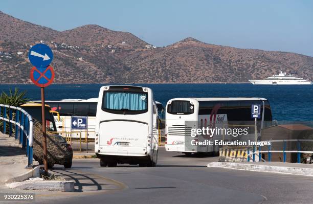 Agios Nikolaos, Crete, Greece. Bus and tourist coach park on the harbor frontage. Taking in a view of the sea and mountains.