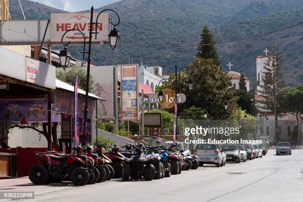 Malia, Lasithi, Crete, Greece, Quad bikes for hire line a street in Malia a seaside resort.