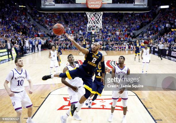 Jevon Carter of the West Virginia Mountaineers drives toward the basket during the Big 12 Basketball Tournament Championship game against the Kansas...