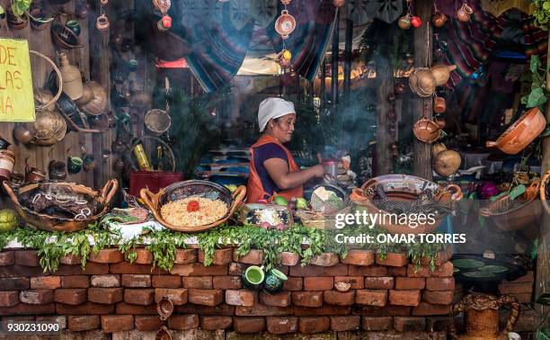 In this file photo taken on October 05 a woman prepares meals with mole at a restaurant during the Mole Fair in San Pedro Atocpan, Milpa Alta...