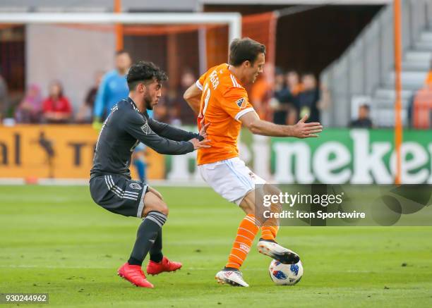 Houston Dynamo forward Andrew Wenger keeps the ball away from Vancouver Whitecaps midfielder Russell Teibert during the soccer match between the...