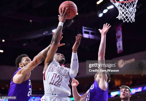 Harris of the New Mexico State Aggies shoots a layup against Keonta Vernon and Casey Benson of the Grand Canyon Lopes during the championship game of...