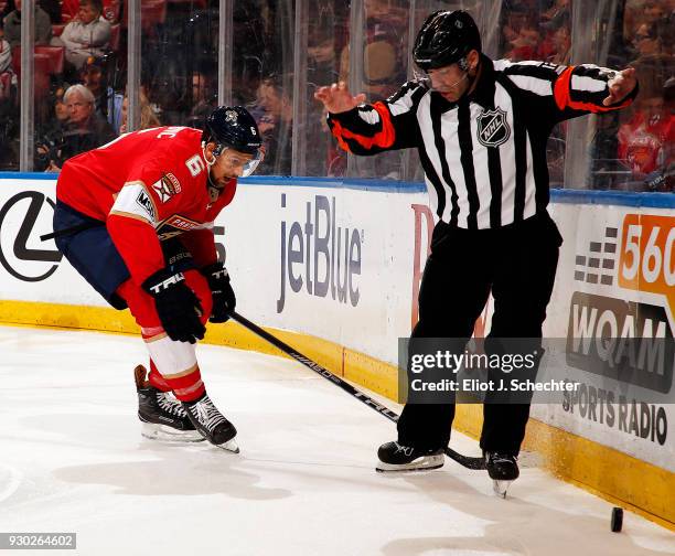 Referee Justin Pierre gets in the way of Alex Petrovic of the Florida Panthers digging the puck out from the boards against the Montreal Canadiens at...