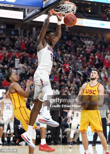 Deandre Ayton of the Arizona Wildcats dunks against Elijah Stewart and Nick Rakocevic of the USC Trojans during the championship game of the Pac-12...
