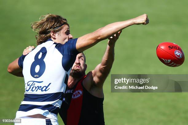 Jake Kolodjashnij of the Cats and Cale Hooker of the Bombers compete for the ball during the JLT Community Series AFL match between the Geelong Cats...