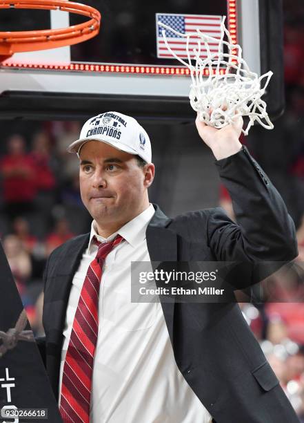 Head coach Sean Miller of the Arizona Wildcats cuts down a net after his team's 75-61 victory over the USC Trojans to win the championship game of...