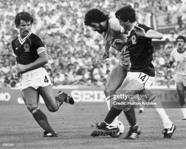 Socrates of Brazil moves in between Graeme Souness and David Narey of Scotland during the FIFA World Cup Finals match played at the Estadio Benito...