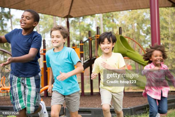 grupo multiétnico de los escolares en el patio de la escuela. - kids playing tag fotografías e imágenes de stock
