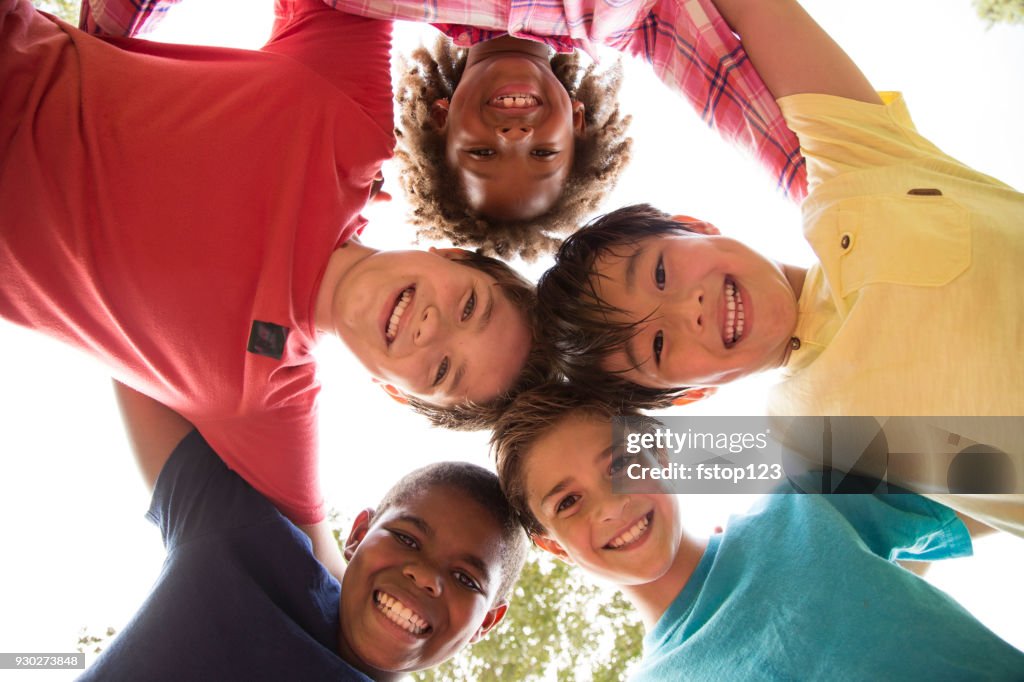 Multi-ethnic group of school children playing on school playground.