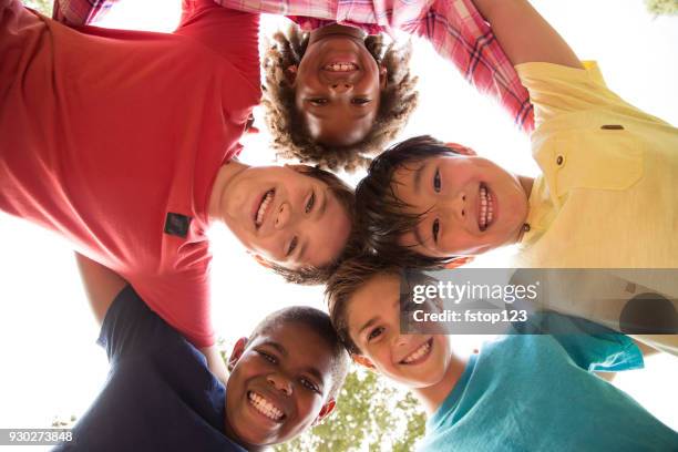 multi-ethnic group of school children playing on school playground. - circle of heads stock pictures, royalty-free photos & images