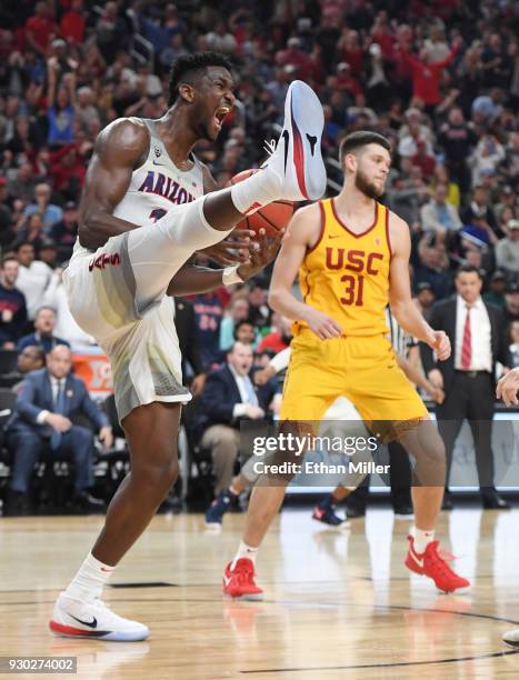 Deandre Ayton of the Arizona Wildcats reacts in front of Nick Rakocevic of the USC Trojans after dunking during the championship game of the Pac-12...