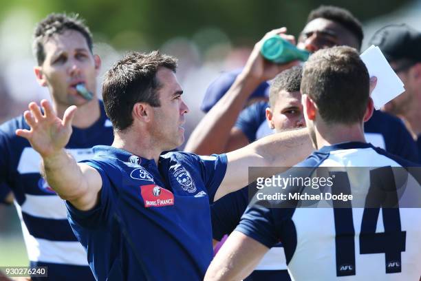 Cats head coach Chris Scott speaks to his players during the JLT Community Series AFL match between the Geelong Cats and the Essendon Bombers at...