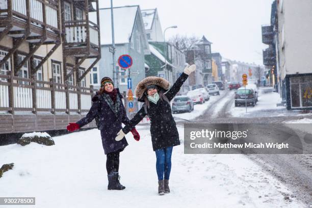 girls walk through the city of reykjavik in the middle of winter. - reykjavik women stockfoto's en -beelden