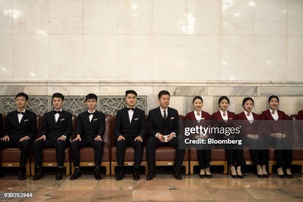 Attendants sit in a hallway inside the Great Hall of the People ahead of a vote to repeal presidential term limits at a session at the first session...