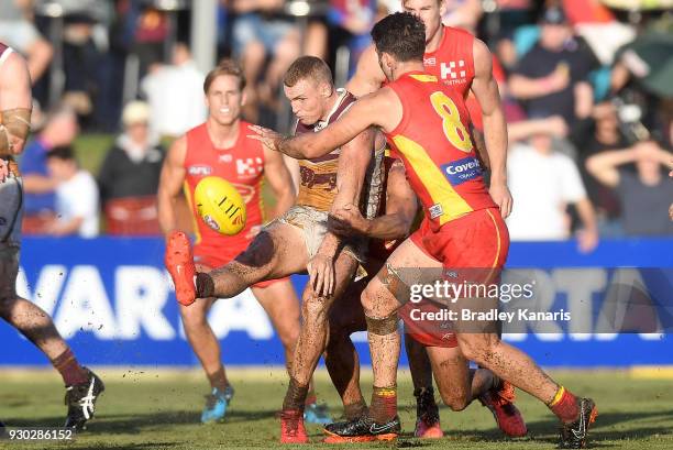 Mitch Robinson of the Lions gets a kick away during the JLT Community Series AFL match between the Gold Coast Suns and the Brisbane Lions at...