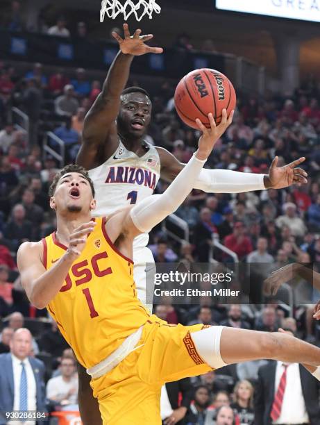 Jordan Usher of the USC Trojans drives to the basket against Rawle Alkins of the Arizona Wildcats during the championship game of the Pac-12...