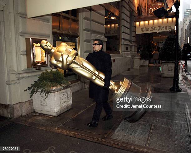 Caesar Perez carries an 8-foot Oscar statue into the St. Regis Hotel in preparation for the Official Academy of Motion Picture Arts & Sciences New...