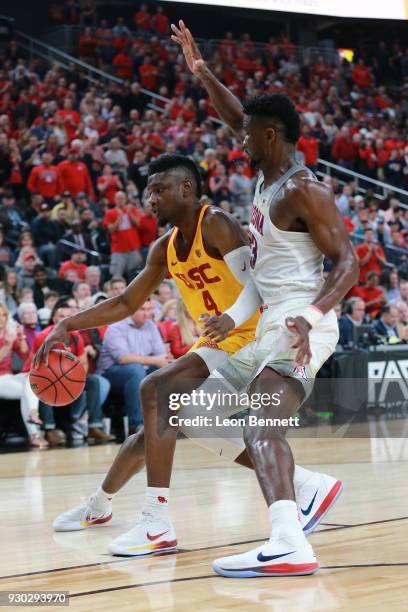 Chimezie Metu of the USC Trojans handles the ball against Deandre Ayton of the Arizona Wildcats during the championship game of the Pac-12 basketball...