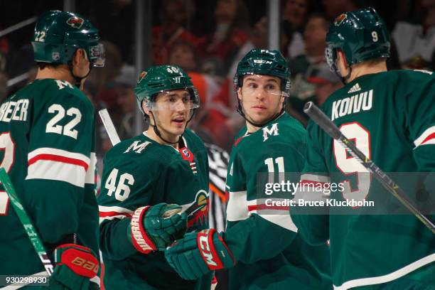 Nino Niederreiter, Jared Spurgeon, Zach Parise and Mikko Koivu of the Minnesota Wild talk during a break in the game against the Detroit Red Wings at...