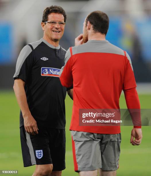 Fabio Capello talks to Wayne Rooney during the England training session at the Khalifa Stadium on November 13, 2009 in Doha, Qatar.