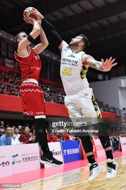 Brendan Lane of the Alvark Tokyo shoots while under pressure from Josh Harrellson of the Sun Rockers Shibuya during the B.League game between Alvark...