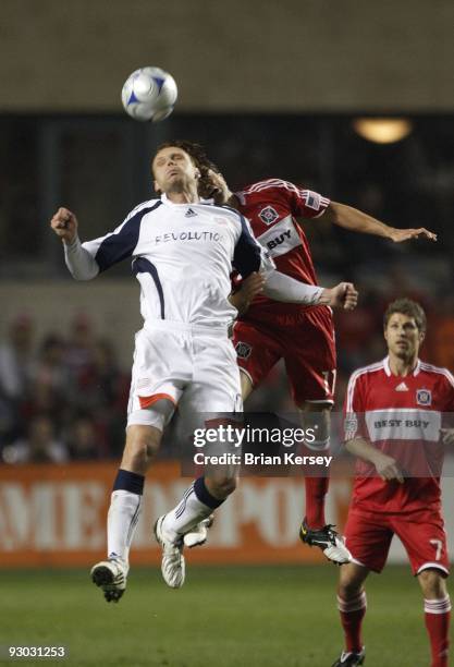 Edgaras Jankauskas of the New England Revolution and John Thorrington of the Chicago Fire go up for a header during the second half of game 2 of the...