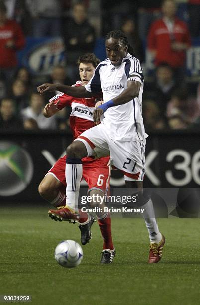 Shalrie Joseph of the New England Revolution kicks the ball as Brandon Prideaux of the Chicago Fire defends during the second half of game 2 of the...