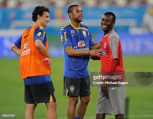 Robinho and Elano of Brazil greet Manchester City team mate Shaun Wright-Phillips of England during the England training session at the Khalifa...