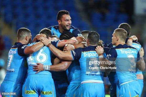 Konrad Hurrell of the Titans celebrates with team mates after scoring a try to win the round one NRL match between the Gold Coast Titans and the...