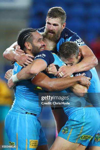 Konrad Hurrell of the Titans celebrates with team mates after scoring a try to win the round one NRL match between the Gold Coast Titans and the...