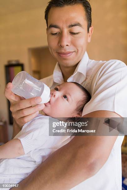 man feeding his son with a baby bottle - frida karlson bildbanksfoton och bilder