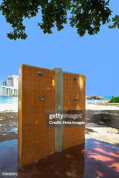 outdoor showers on an empty beach, condado beach, san juan, puerto rico - condado beach stock pictures, royalty-free photos & images