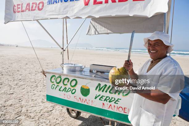 man cutting a coconut with a machete - cutting coconuts stock pictures, royalty-free photos & images
