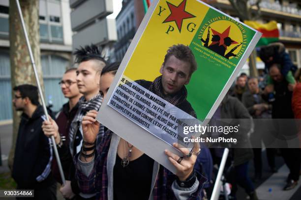 Anarchists brandish a placard depicting an Icelandic anarchist killed by Turkish army in Afrin'. Kurds demonstrate to pay tribute to French fighter...