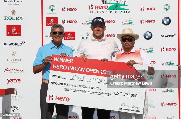 Matt Wallace of England is presented with a cheque by Director of The European Tour David Williams and Chairman of Hero MotoCorp Pawan Munjal after...