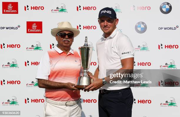 Matt Wallace of England is presented with the trophy by Chairman of Hero MotoCorp Pawan Munjal after winning the play off during day four of The Hero...