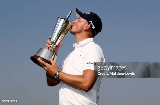 Matt Wallace of England poses for a picture with the trophy after winning the play off during day four of The Hero Indian Open at Dlf Golf and...
