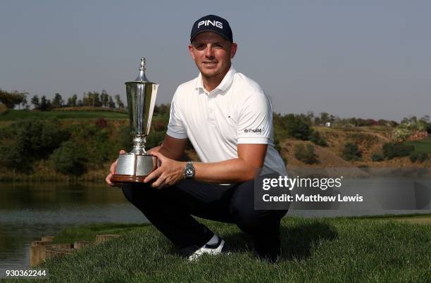 Matt Wallace of England poses for a picture with the trophy after winning the play off during day four of The Hero Indian Open at Dlf Golf and...