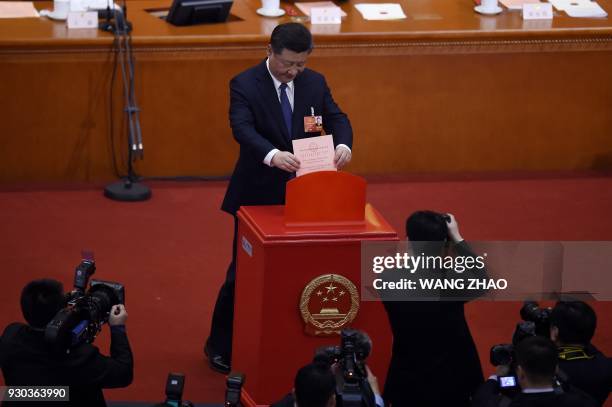 Chinese President Xi Jinping votes during the third plenary session of the first session of the 13th National People's Congress at the Great Hall of...