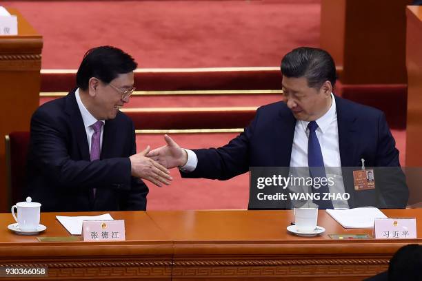 China's President Xi Jinping shakes hands with National People's Congress Chairman Zhang Dejiang during the third plenary session of the first...