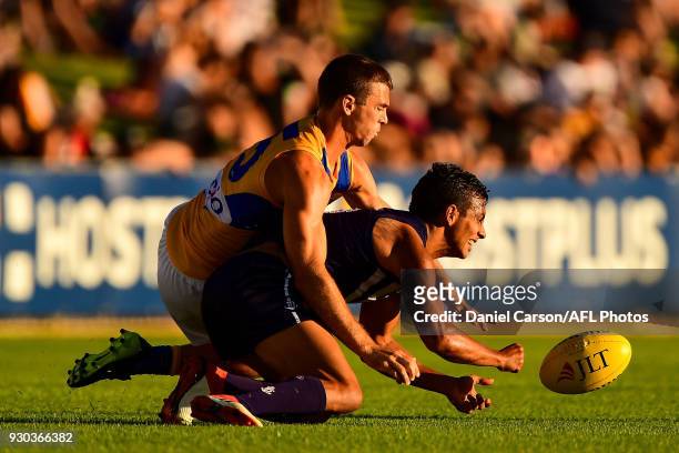 Danyle Pearce of the Dockers handpasses the ball under pressure from Jamie Cripps of the Eagles during the AFL 2018 JLT Community Series match...