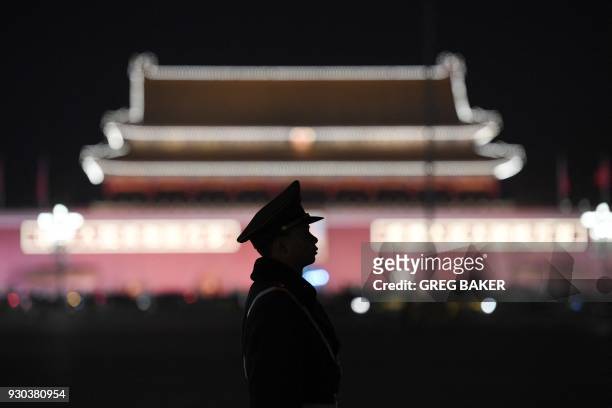 Paramilitary police officer stands guard in Tiananmen Square after a plenary session of the National People's Congress in the adjacent Great Hall of...