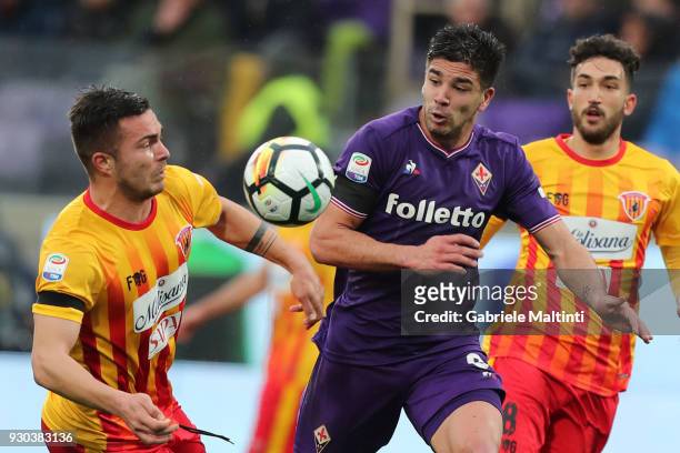 Giovanni Simeone of ACF Fiorentina battles for the ball with Alin Dorinel Tosca of Benevento Calcio during the serie A match between ACF Fiorentina...