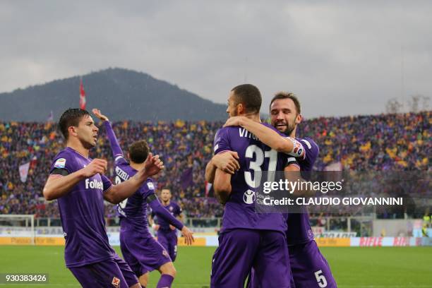 Fiorentina's defender Vitor Hugo celebrates with teammates after scoring on March 11, 2018 during the Italian Serie A football match Fiorentina vs...