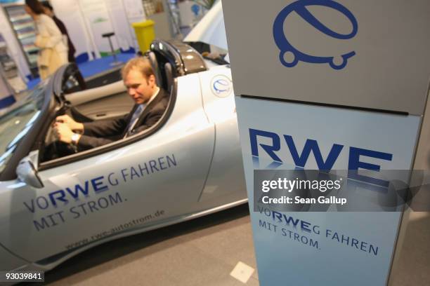 Visitor sits in a Tesla Roadster electric car at the stand of German utility RWE at the party congress of the German Social Democrats on November 13,...